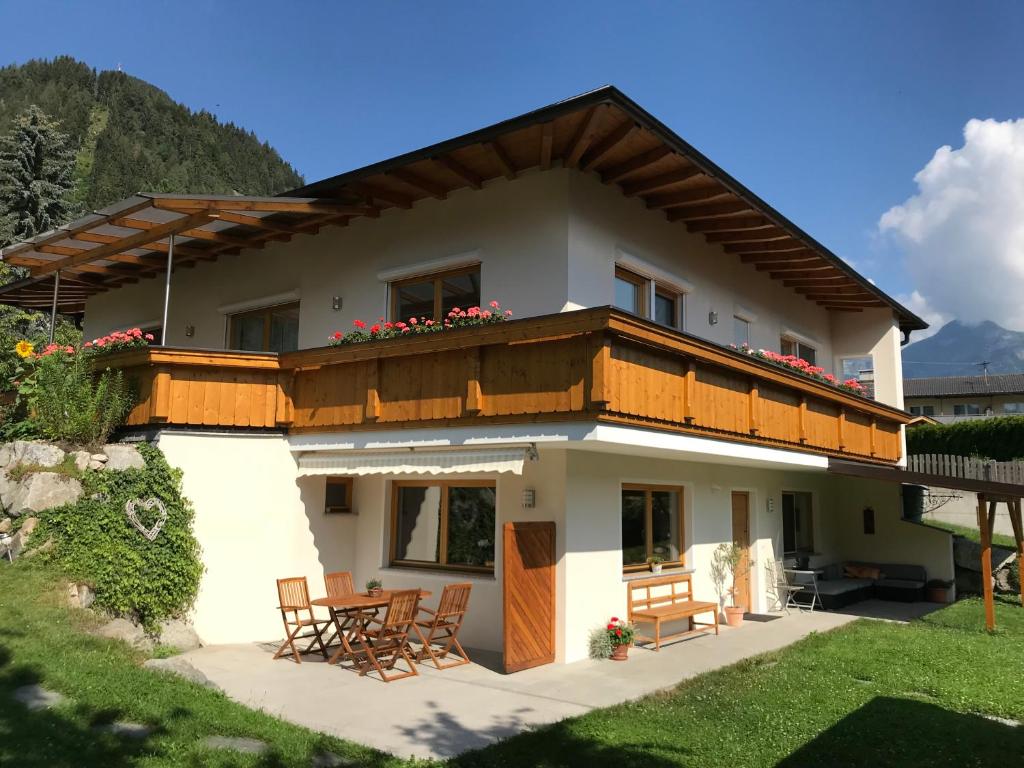 a house with a balcony and a table at Ferienwohnung Martina in Schlitters