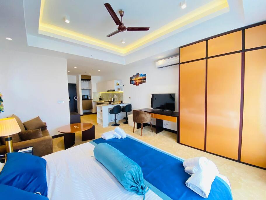 a bedroom with a blue bed and a living room at Fun-Ocean-Chill in Negombo