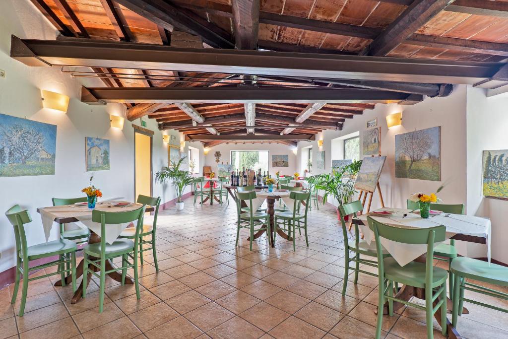 restauracja ze stołami i krzesłami w pokoju w obiekcie Casalchino-Fattoria La Torre w mieście San Gimignano