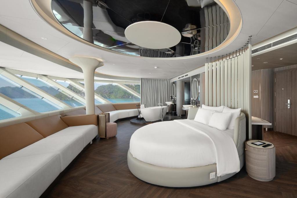a bedroom with a large bed in a suite on a yacht at Grand Pioneers Halong Bay Cruise 1 in Ha Long