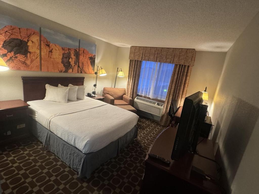 a hotel room with a bed and a television at Days Inn by Wyndham Sturgis in Sturgis