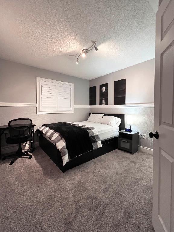 1 dormitorio con 1 cama y 1 silla en A Room in Oshawa, Free Parking, en Oshawa
