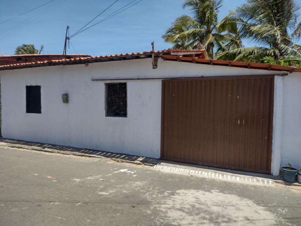 um edifício branco com uma porta de garagem castanha em Casa Village Praia em Almfala