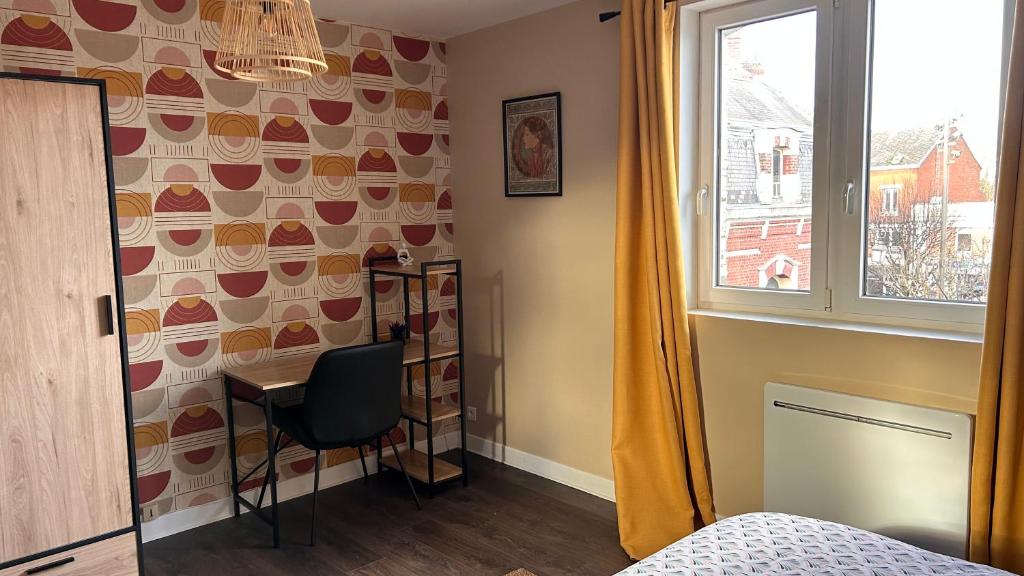 a bedroom with a desk and a window at L'appartement de Julie in Albert