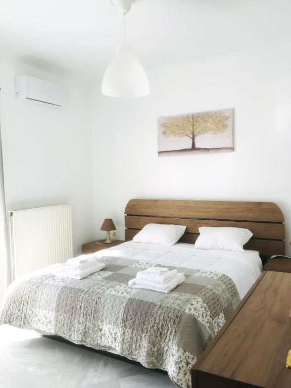 een slaapkamer met een groot bed met een houten hoofdeinde bij Central Family Apartment in Preveza