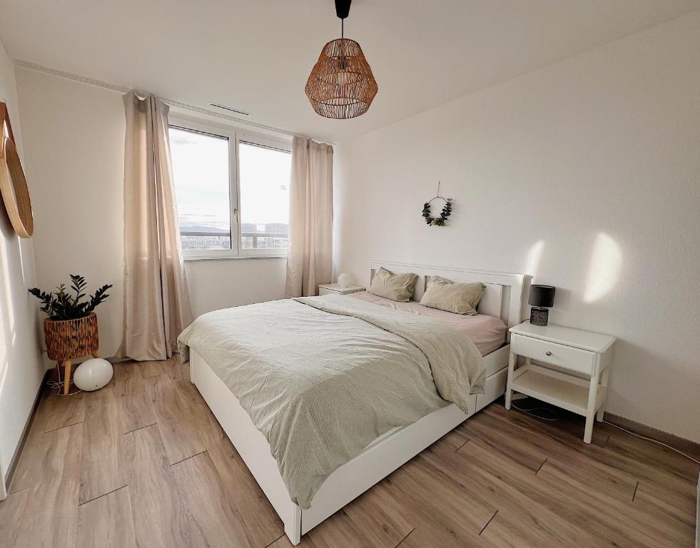 Habitación blanca con cama y ventana en Beautiful Apartment 10 min from Zurich! Netflix!, en Schlieren