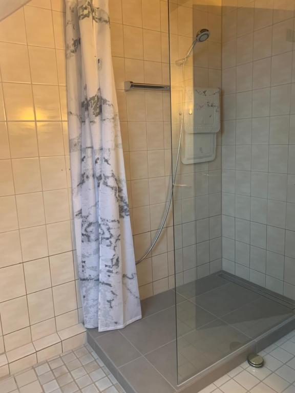 y baño con ducha y cortina de ducha. en Ferienwohnung, en Oberems