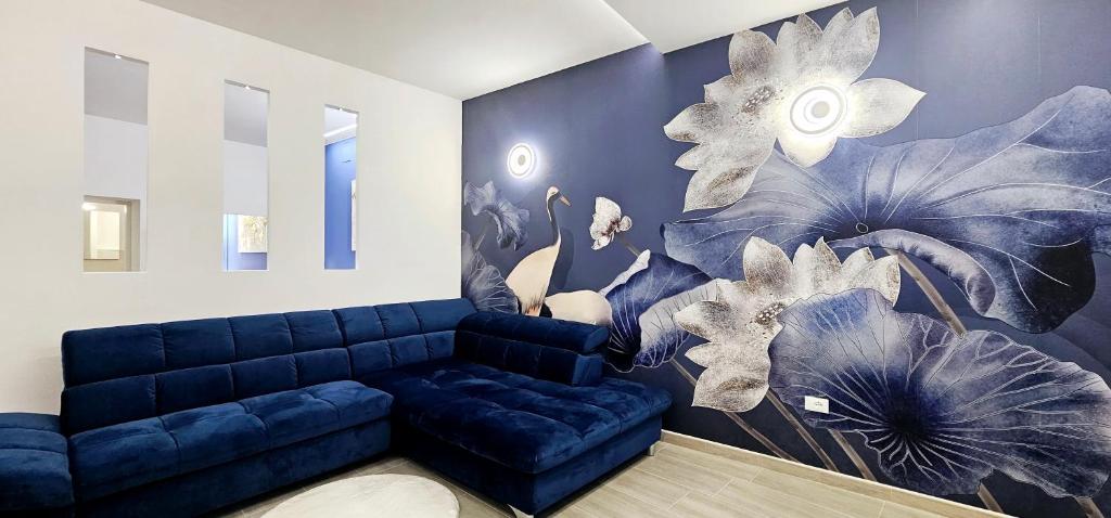 uma sala de estar com um sofá azul e um mural de flores em Garibaldi Superior Apartment - Enjoy Your Life! em Faenza