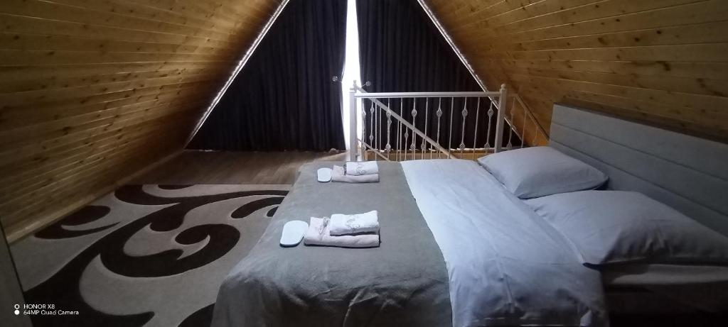 Una cama en una habitación de madera con toallas. en Qusar-A-frame en Qusar