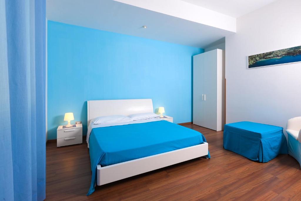a blue bedroom with a bed and two stools at Bed And Breakfast Sunflower in Vico Equense