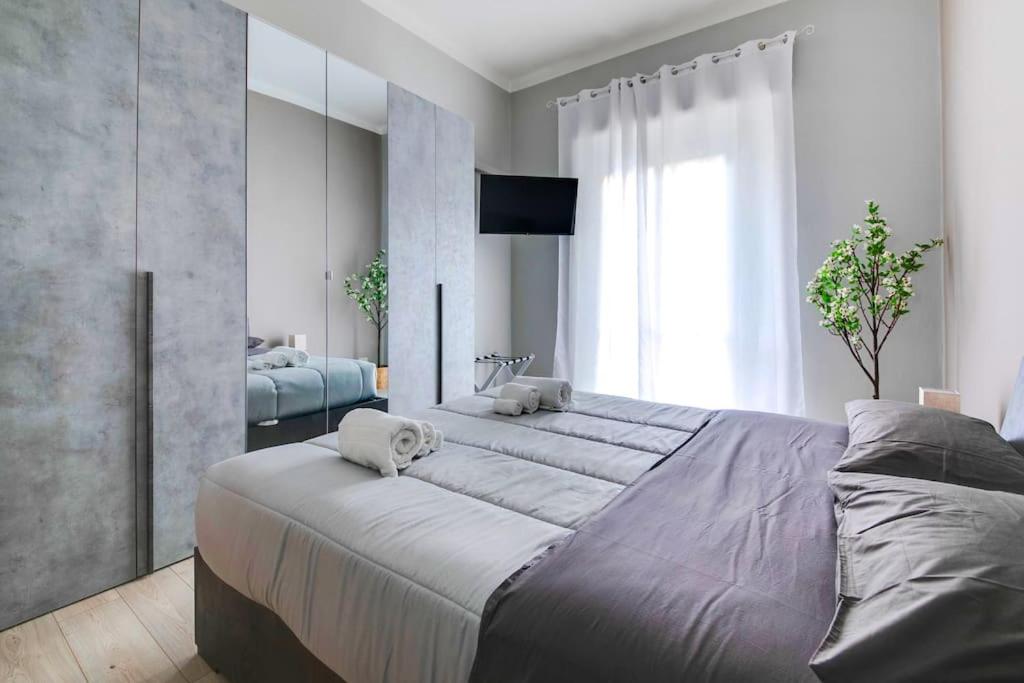 - une chambre avec 2 lits et une grande fenêtre dans l'établissement [The Garden] Centro Storico + Free Parking + Wi-Fi, à Reggio d'Émilie