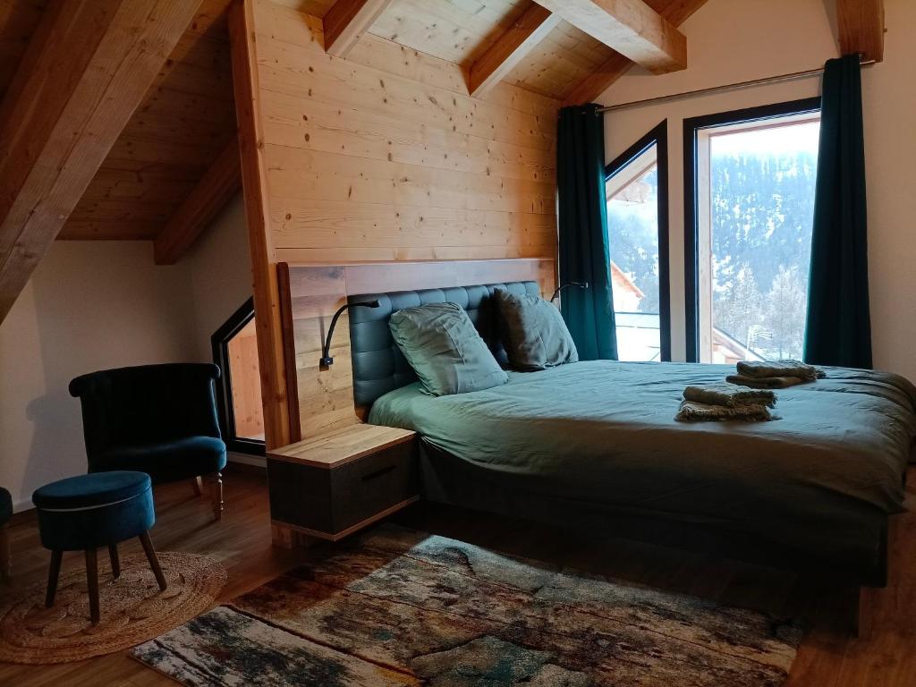 a bedroom with a bed and a large window at Chalet Kelly in Les Orres