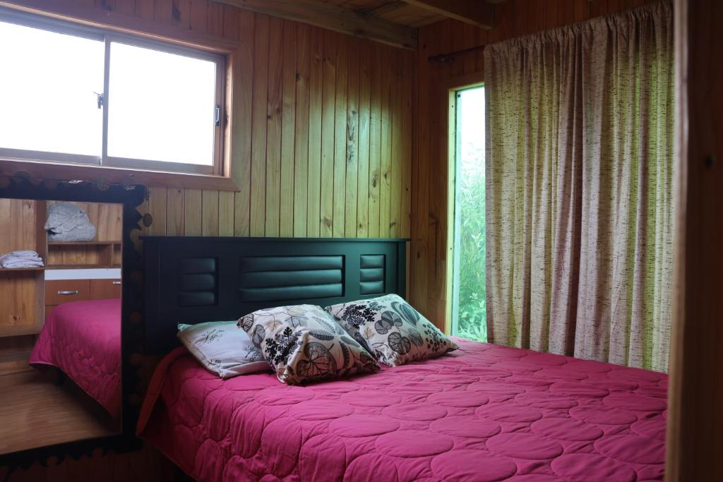 1 dormitorio con cama con sábanas rosas y ventana en Casa infiernillo, en Pichilemu