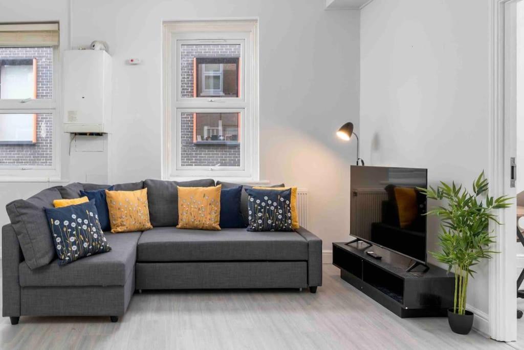 a living room with a couch and a tv at Large Brick Lane Apartment - 1st Floor in London