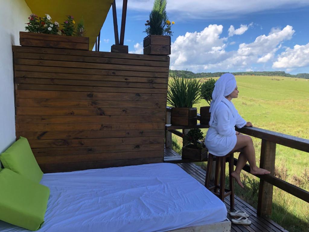 カンバラにあるVale de cambara Iの女性がバルコニーの手すりに座っている