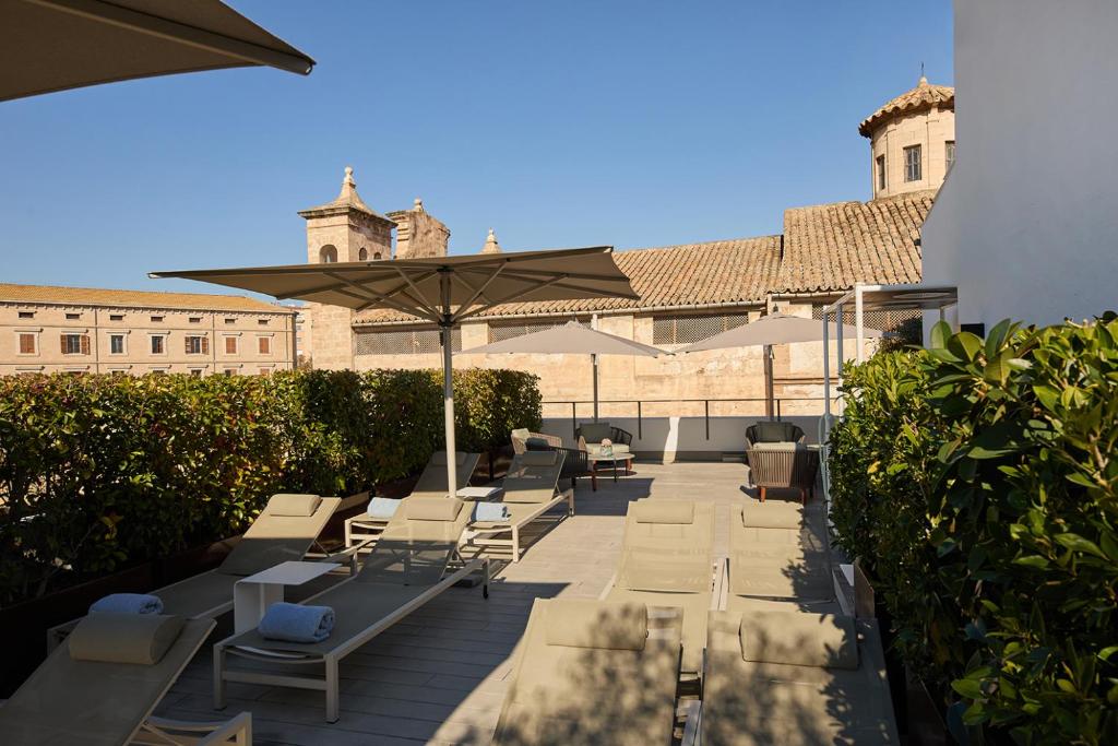 a patio with lounge chairs and an umbrella at Sant Jaume Design Hotel in Palma de Mallorca