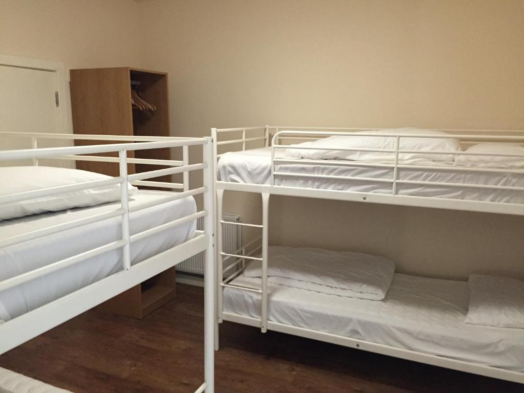 a room with two bunk beds with white bunkitures at The Anchor Hotel & Bars in Ingoldmells