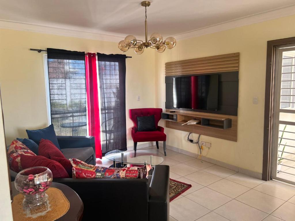- un salon avec un canapé et une télévision dans l'établissement Apartment near Airport & beach security 24/7, à La Cana