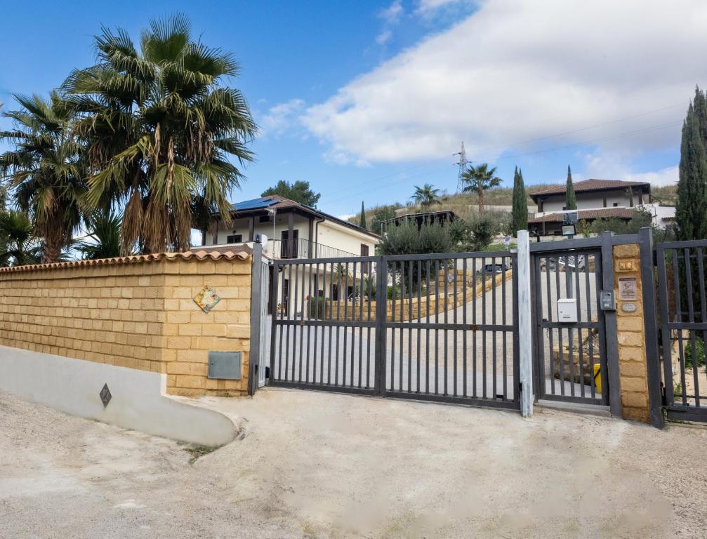 una recinzione di metallo con un cancello di fronte a una casa di Villa Lory a Agrigento