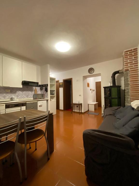 ein Wohnzimmer mit einem Sofa und einem Tisch sowie eine Küche in der Unterkunft Perla alpina in Abetone