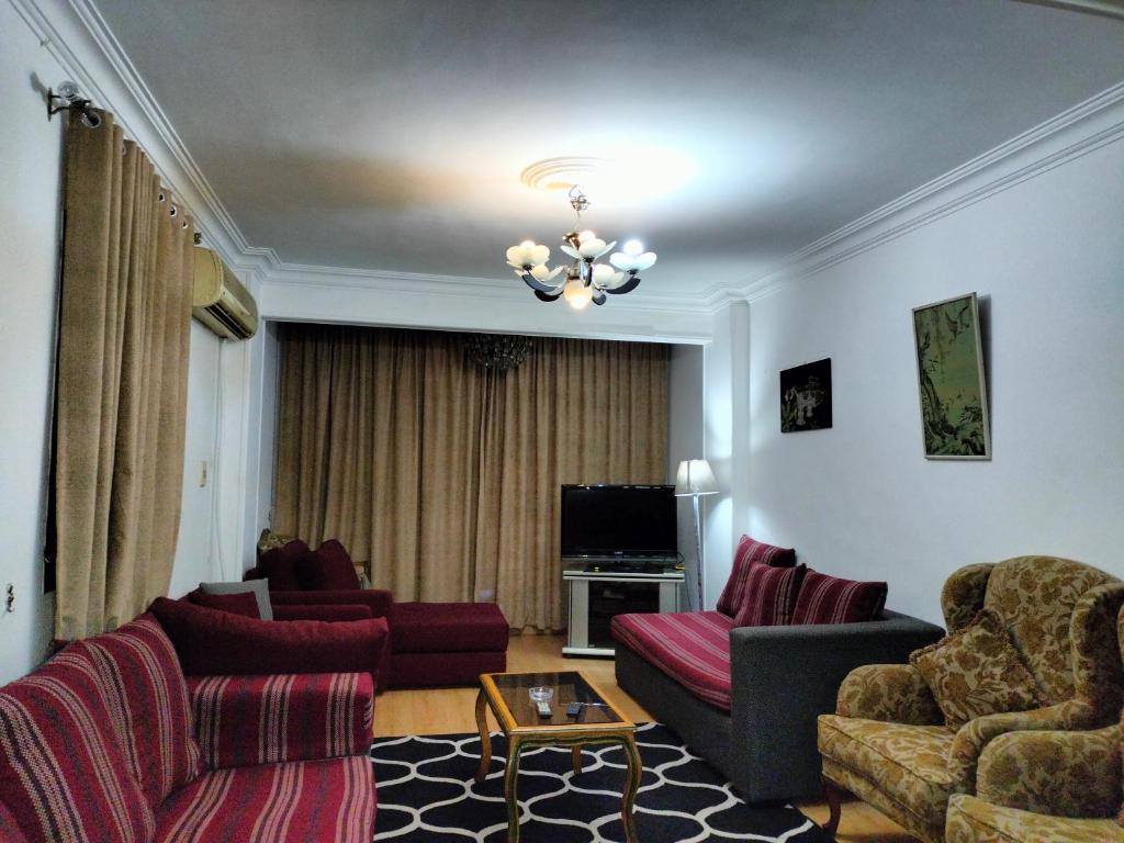 een woonkamer met 2 banken en een televisie bij Dokki private home with 2 rooms WiFi Air-conditioning in Caïro