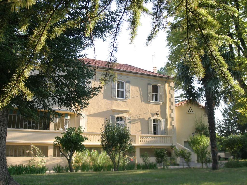 Cette grande maison jaune possède un balcon dans la cour. dans l'établissement Beautiful appartment with pool in Provence, à Valréas