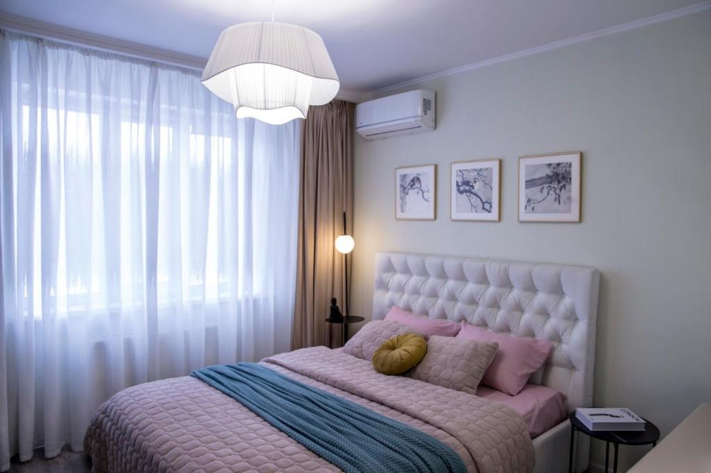 a bedroom with a large bed with pink and blue sheets at Апартаменты Металлист посуточно ЛЮКС in Kharkiv