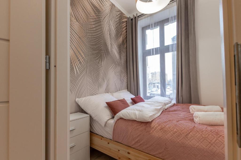 ein kleines Schlafzimmer mit einem Bett und einem Fenster in der Unterkunft Chill Apartments Central Station Katowice in Kattowitz