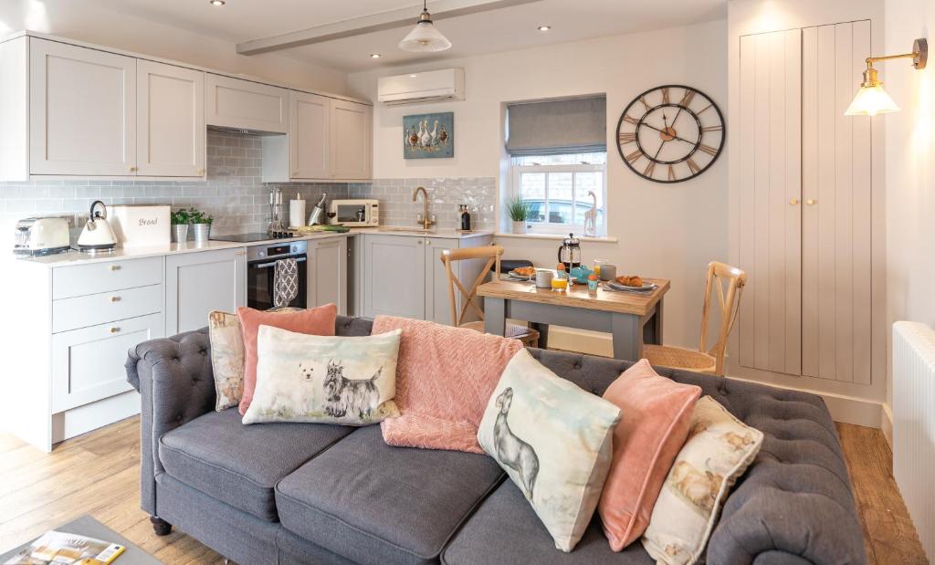 a living room with a couch and a kitchen at Honey Pot, Chipping Campden, parking, garden, late check-out in Chipping Campden