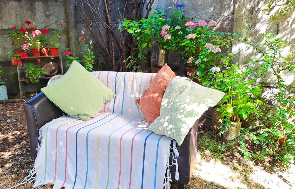 a striped couch with pillows sitting in a garden at 2 personas, desayuno, gran ubicación in Osorno