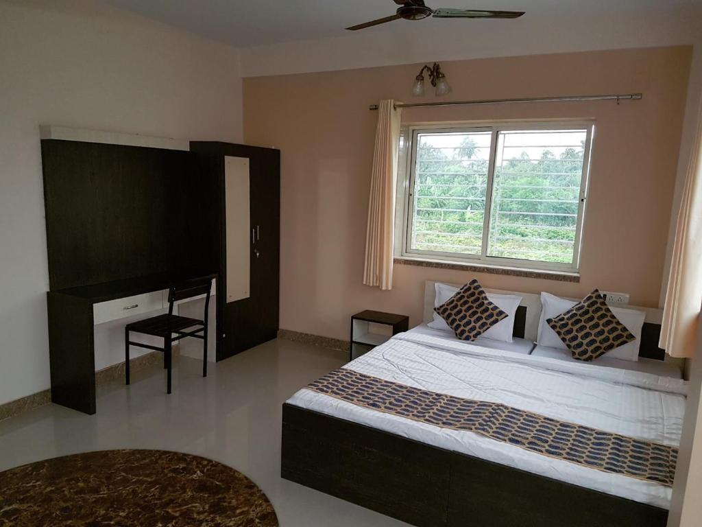 a bedroom with a large bed and a window at LOTUS APARTMENTS HOTEL in kolkata
