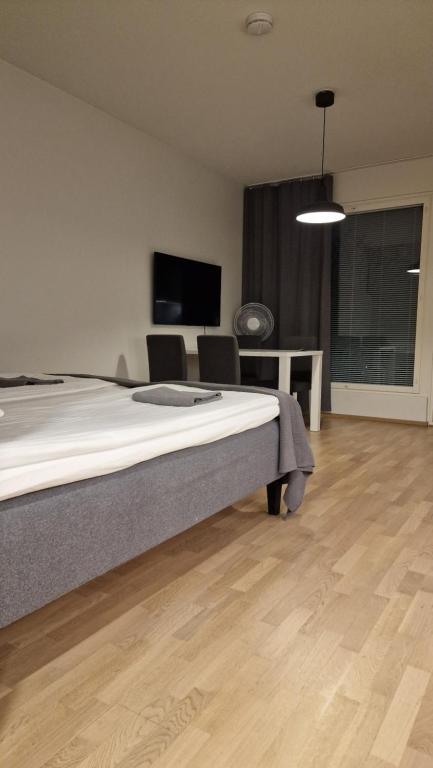 a bedroom with a bed and a flat screen tv at Home away near services in Turku
