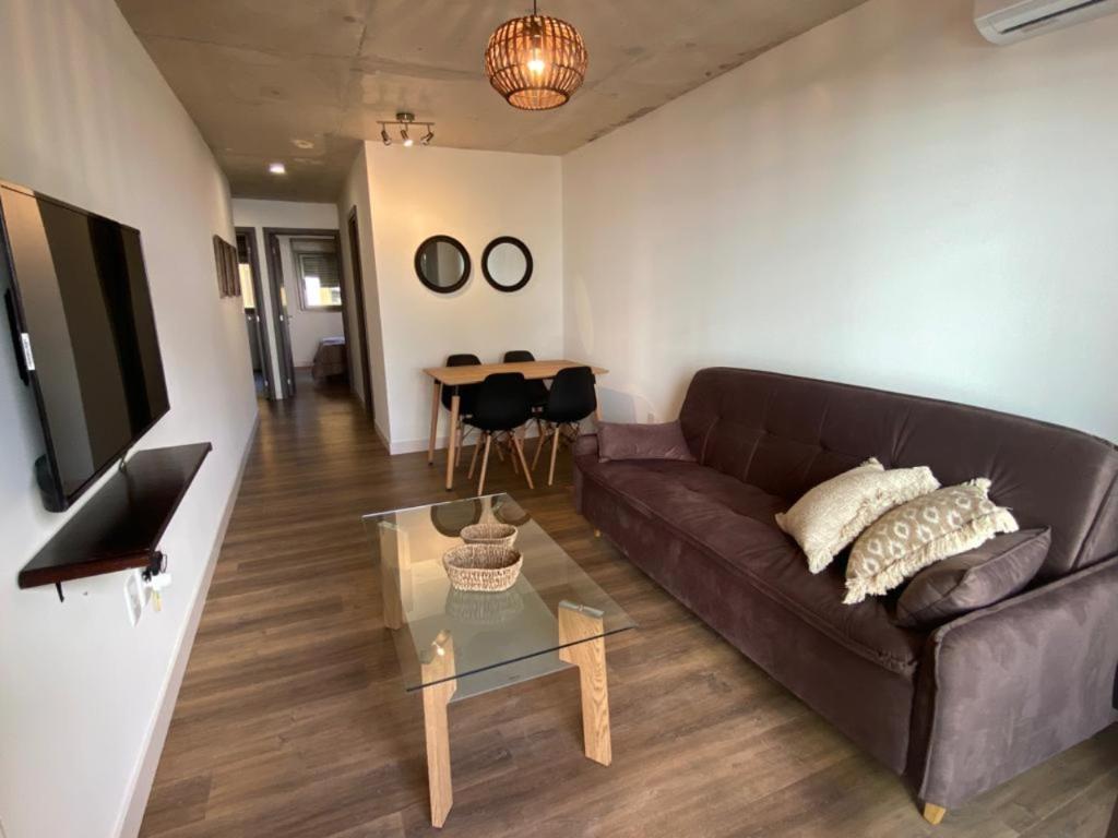 蒙特維多的住宿－Excelente apto 1 dorm completo，客厅配有棕色沙发和桌子