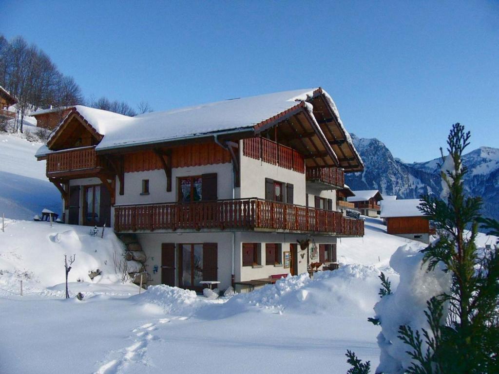 een besneeuwd huis met een balkon in de sneeuw bij Gand chalet montagne 30 personnes in Bernex