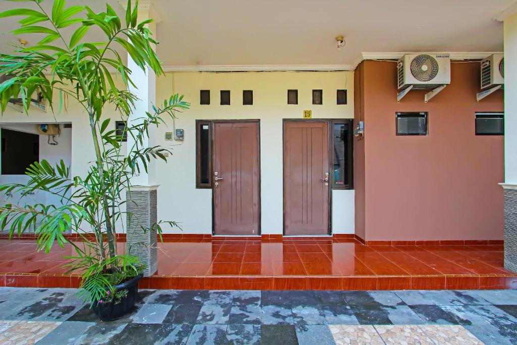 ein Gebäude mit zwei Türen und Pflanzen im Innenhof in der Unterkunft Super OYO 92437 Wahidin Guesthouse in Pekalongan