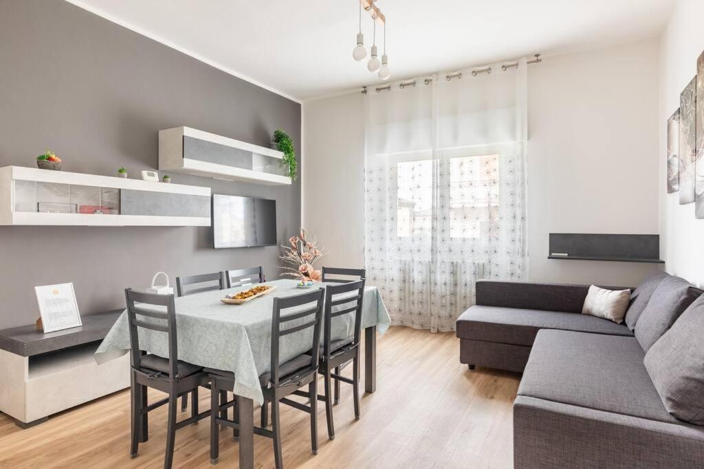 a living room with a table and chairs and a couch at monji apartment in Faenza