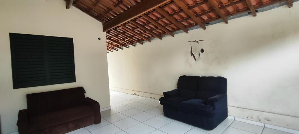 Casa Da Rua Da Pedra في ساو جوزيه دوس كامبوس: غرفة معيشة مع كرسي أزرق ونافذة