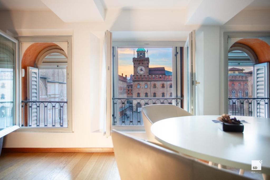 a room with a view of a building with a clock tower at Urbanicooh Asinelli - Balcony on Piazza Maggiore in Bologna