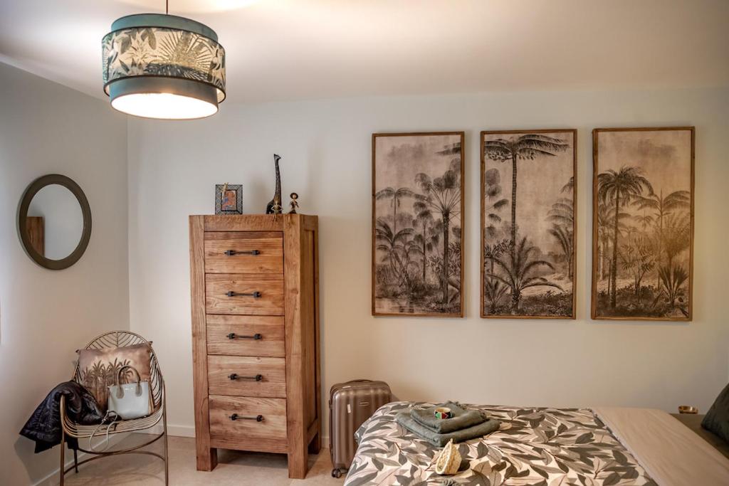 a bedroom with four pictures of palm trees on the wall at Mas de Ceoulet - Villa de Luxe en Camargue in Arles