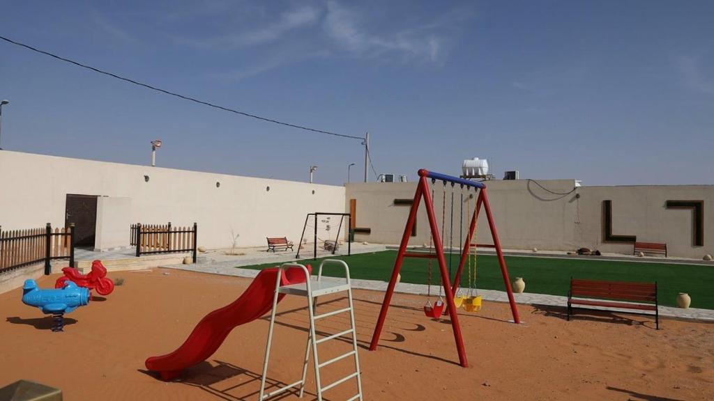 a playground with a slide and a swing at شاليه أمي لولوة in Az Zulfi