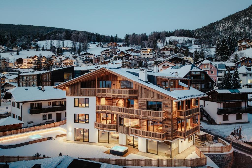 a house in the middle of a town with snow at Chalet Milé in Ortisei