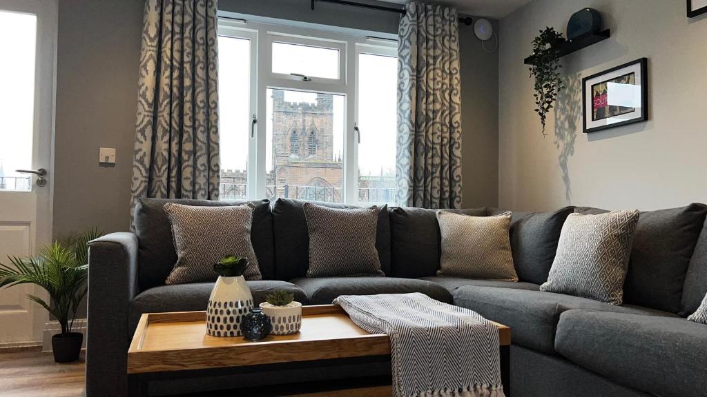 a living room with a couch and a table at Penthouse On The Rows - Cathedral Views in Chester