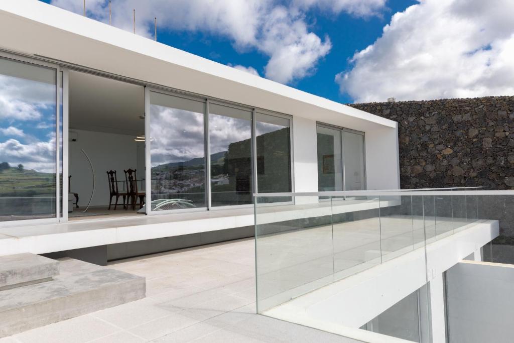 une extension en verre d'une maison avec balcon dans l'établissement Casa Neptuno-Lagoa São Miguel, à Lagoa