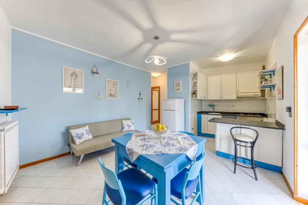eine Küche und ein Wohnzimmer mit einem Tisch und Stühlen in der Unterkunft Appartamento climatizzato con vista mare a 50 m dalla spiaggia in Lido Marini