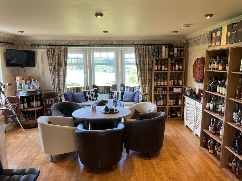 uma sala de estar com uma mesa e cadeiras num quarto em The Gables Whisky B&B em Dufftown