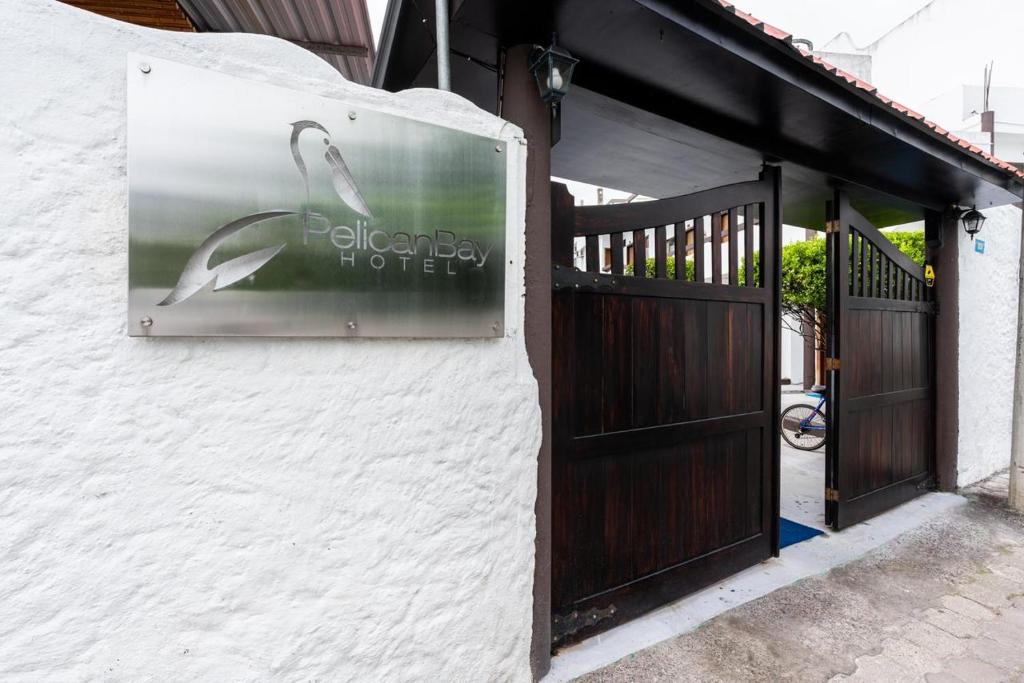 una señal en el lateral de un edificio con una puerta en Hotel Pelican Bay en Puerto Ayora