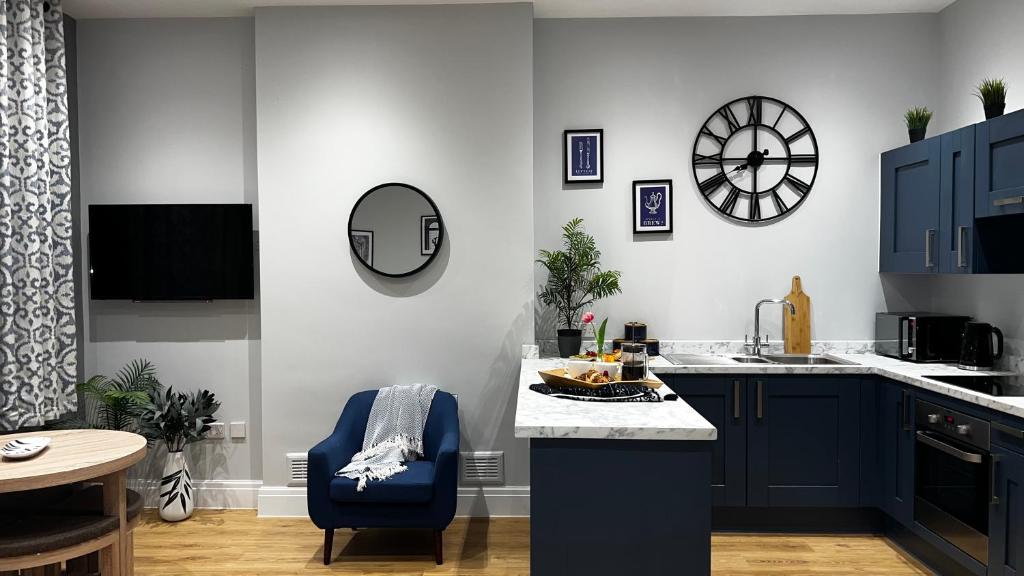 a kitchen with blue cabinets and a blue chair at Romance On The Rows - Hot Tub City Centre in Chester