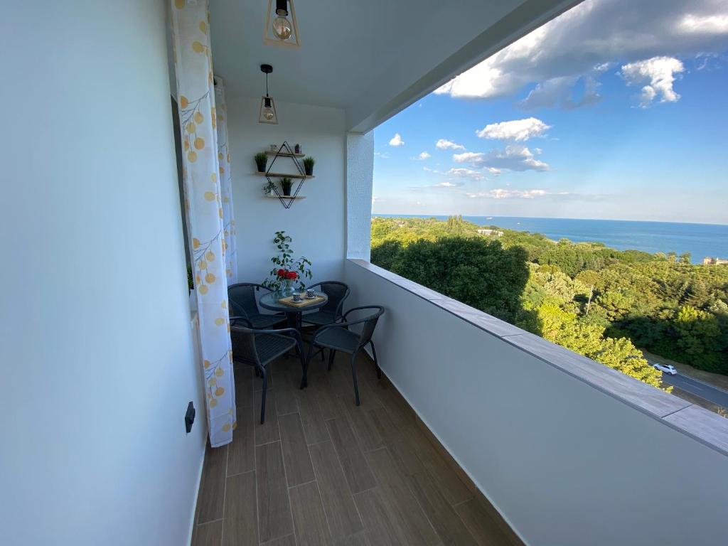 瓦爾納的住宿－Unique Sea View，阳台配有桌子,享有海景。