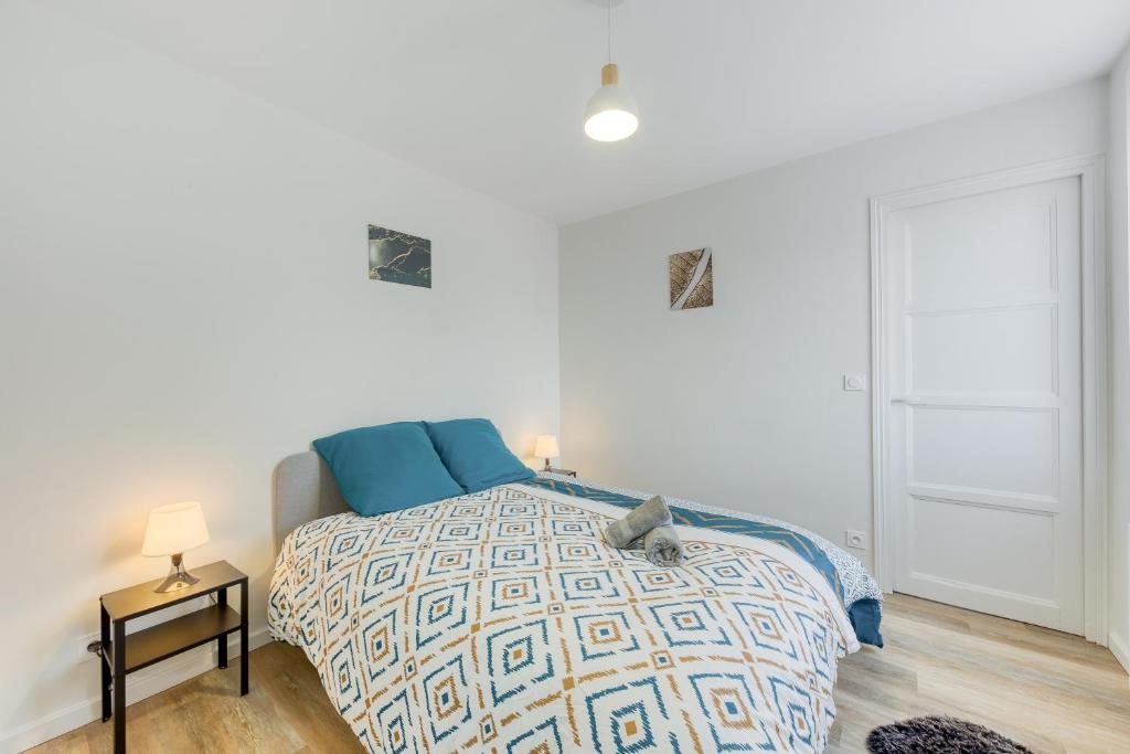 1 dormitorio con 1 cama y 1 mesa con lámpara en Cozy Appart 5 à 3' de la gare - Cozy Houses, en Palaiseau