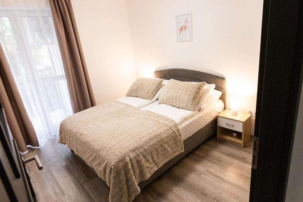 a bedroom with a bed and a window at SunSuite Szeged in Szeged